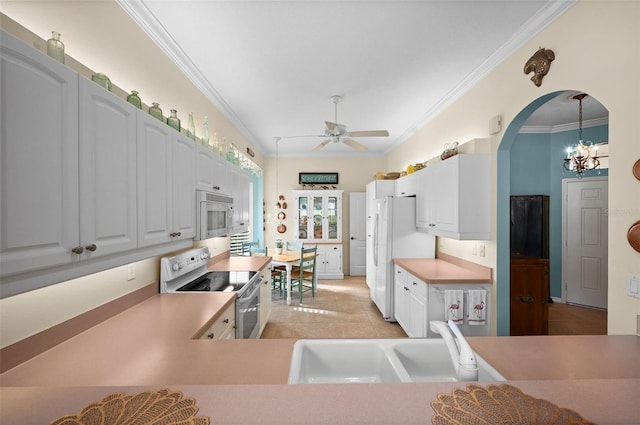 kitchen with sink, decorative light fixtures, ornamental molding, white appliances, and white cabinets