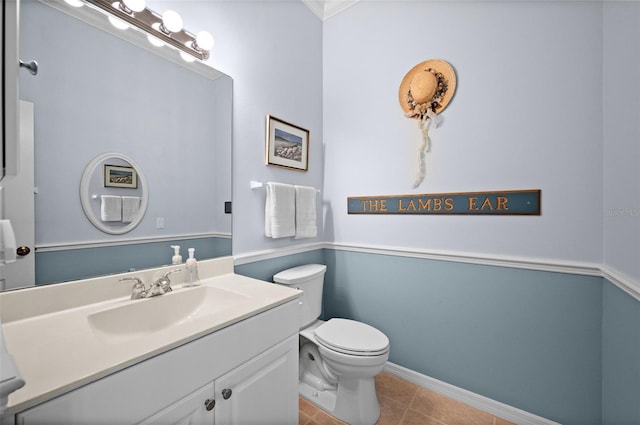 bathroom featuring tile patterned flooring, ornamental molding, vanity, and toilet