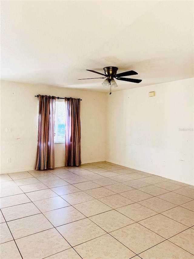 tiled empty room featuring ceiling fan