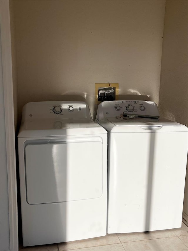 laundry room featuring washing machine and dryer and light tile patterned floors