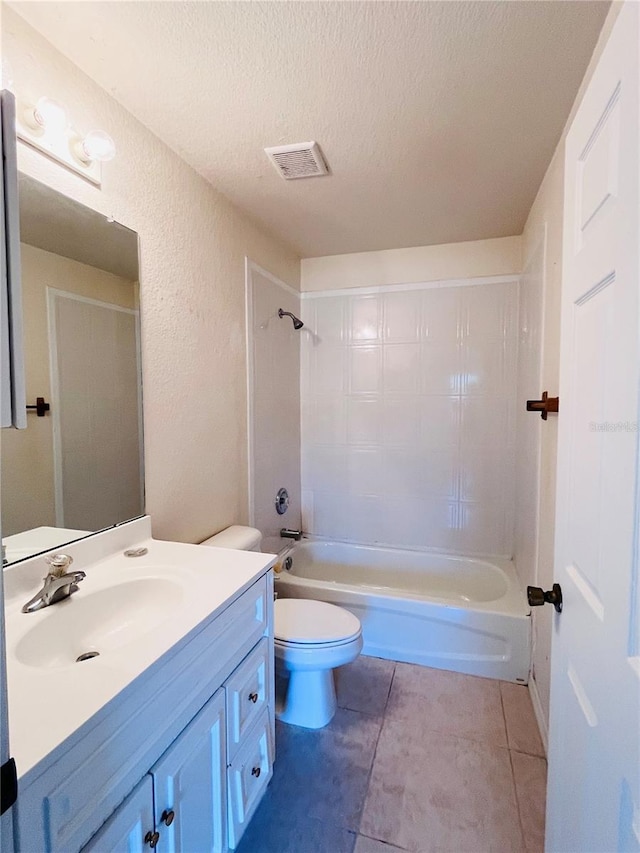 full bathroom featuring shower / washtub combination, vanity, a textured ceiling, tile patterned floors, and toilet