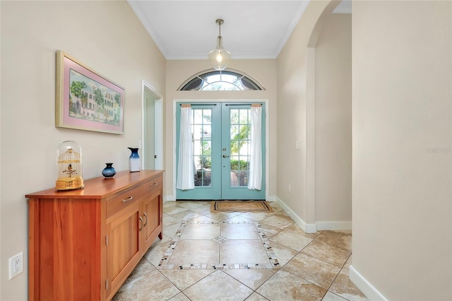 foyer entrance with light tile patterned floors, baseboards, arched walkways, ornamental molding, and french doors