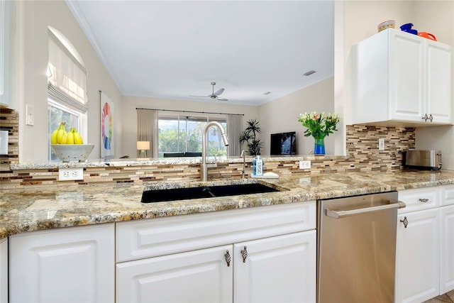 kitchen featuring light stone counters, white cabinetry, a sink, and dishwasher