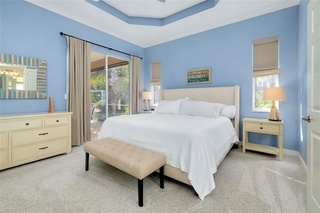 bedroom featuring baseboards, access to outside, a tray ceiling, and light colored carpet