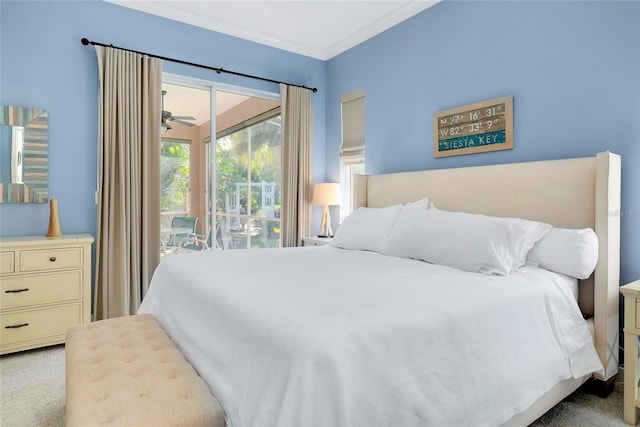 bedroom with access to exterior, light colored carpet, and ornamental molding