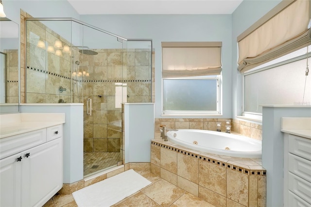 bathroom featuring a stall shower, a jetted tub, and vanity