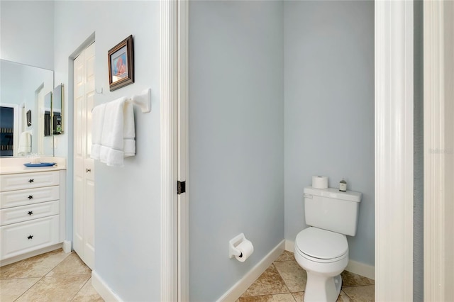 bathroom with baseboards, vanity, toilet, and tile patterned floors