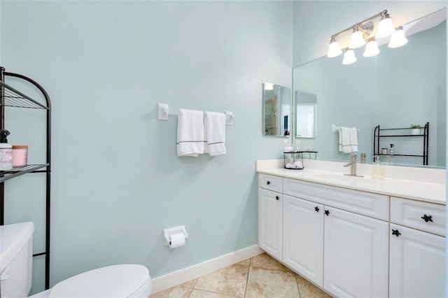 bathroom featuring toilet, vanity, baseboards, and tile patterned floors