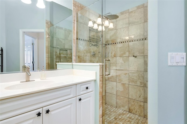 full bath featuring a shower stall, vanity, and an inviting chandelier