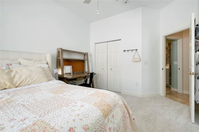 carpeted bedroom with ceiling fan, a closet, and baseboards