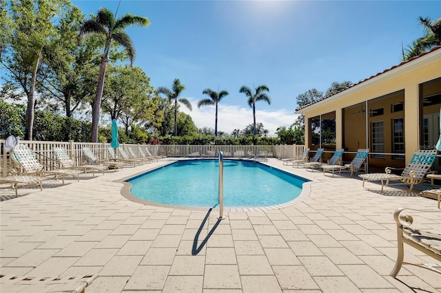 pool with a patio and fence