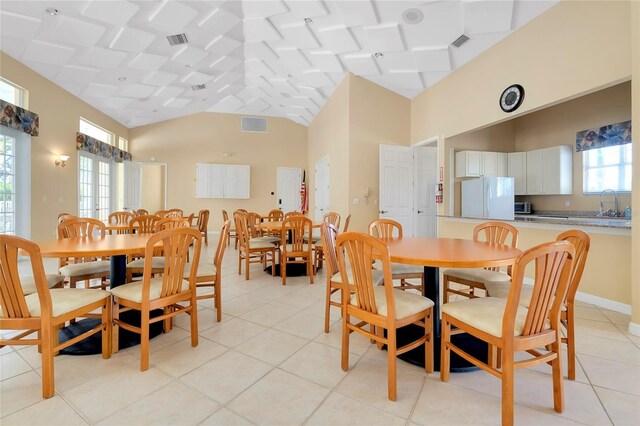 dining room featuring lofted ceiling, visible vents, and light tile patterned floors