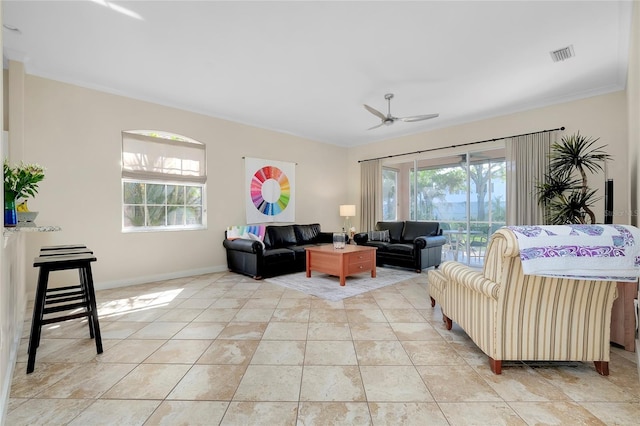 living room with ceiling fan, a wealth of natural light, baseboards, and visible vents
