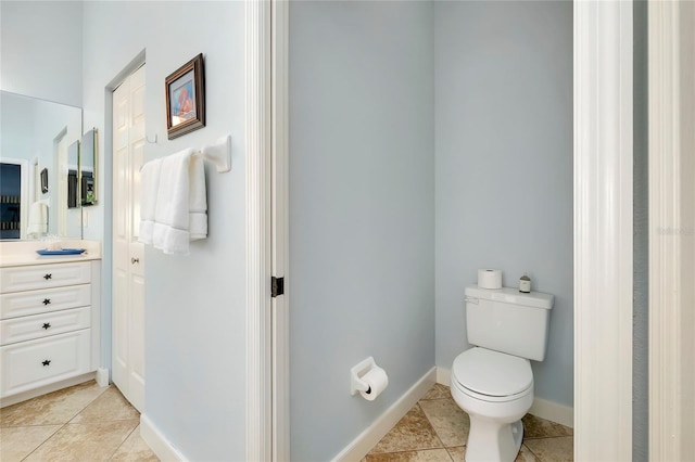 bathroom with vanity, toilet, baseboards, and tile patterned floors