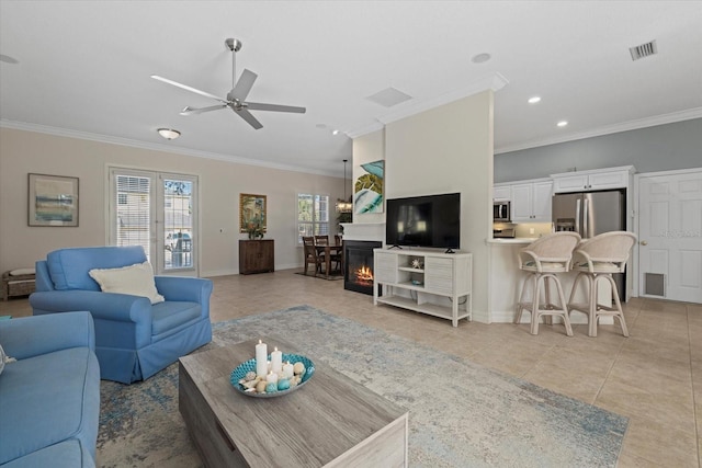 living room featuring crown molding, ceiling fan, light tile patterned floors, and a wealth of natural light