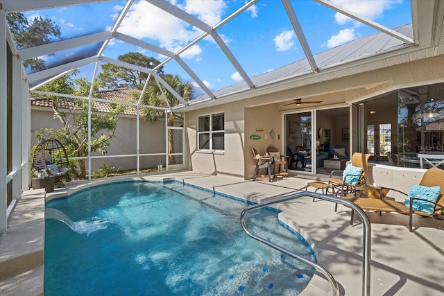 view of pool featuring pool water feature, a lanai, ceiling fan, and a patio area