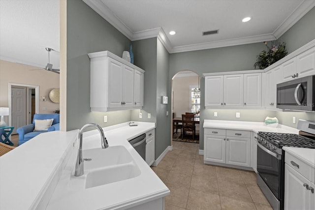 kitchen with stainless steel appliances, white cabinetry, sink, and ornamental molding