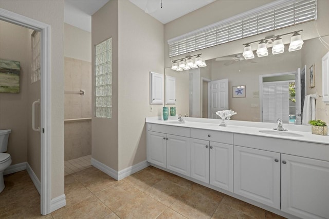 bathroom with tiled shower, toilet, vanity, ceiling fan, and a healthy amount of sunlight