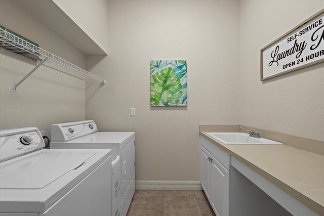 washroom featuring cabinets, sink, light tile patterned floors, and washing machine and clothes dryer