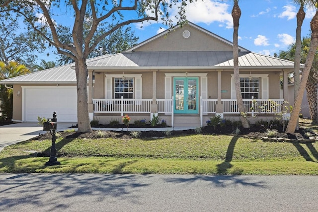 view of front of house featuring a garage, covered porch, and a front lawn