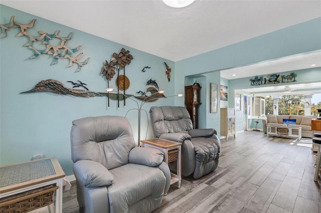 living area with baseboards and wood finished floors