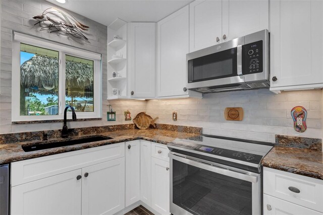 kitchen featuring white cabinets, tasteful backsplash, stainless steel appliances, and a sink