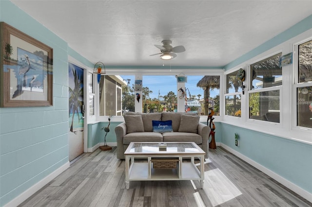 sunroom featuring a ceiling fan