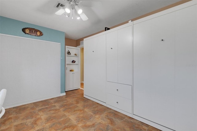 unfurnished bedroom with stone finish flooring, visible vents, and a ceiling fan