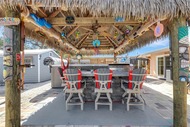 view of patio with an outbuilding, outdoor dry bar, a gazebo, and a storage shed