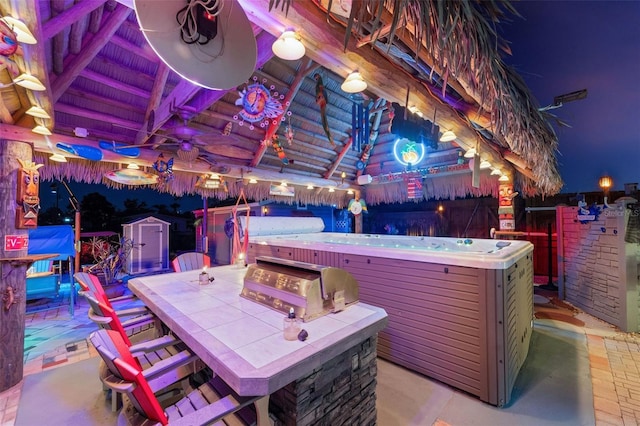 view of patio with outdoor dry bar, fence, a grill, and a hot tub