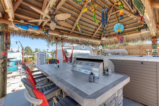 view of patio / terrace with a shed, an outbuilding, ceiling fan, and a gazebo