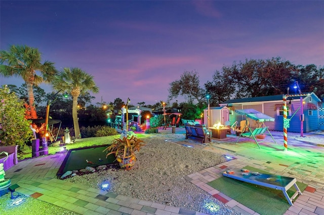 view of playground with an outdoor fire pit and a patio