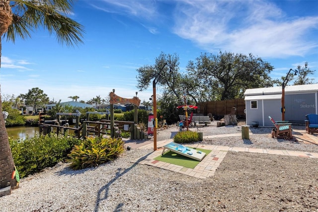 view of yard with a dock, boat lift, and fence