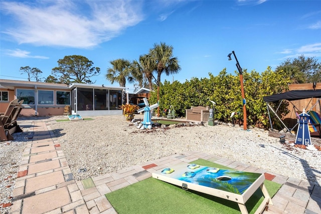 exterior space with an outbuilding, a sunroom, a patio area, and a storage shed