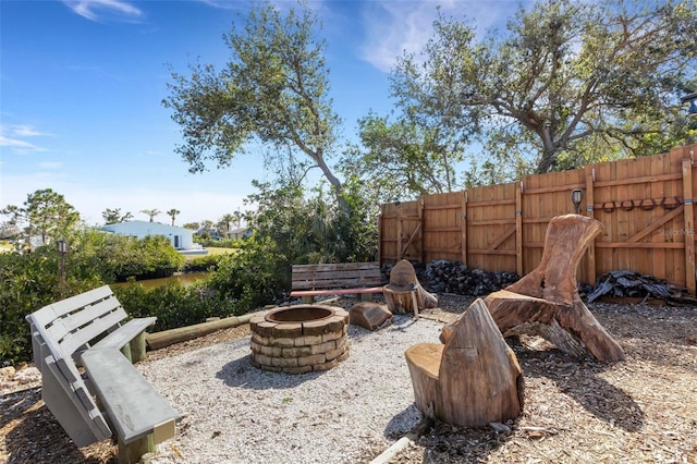 view of yard featuring an outdoor fire pit and fence