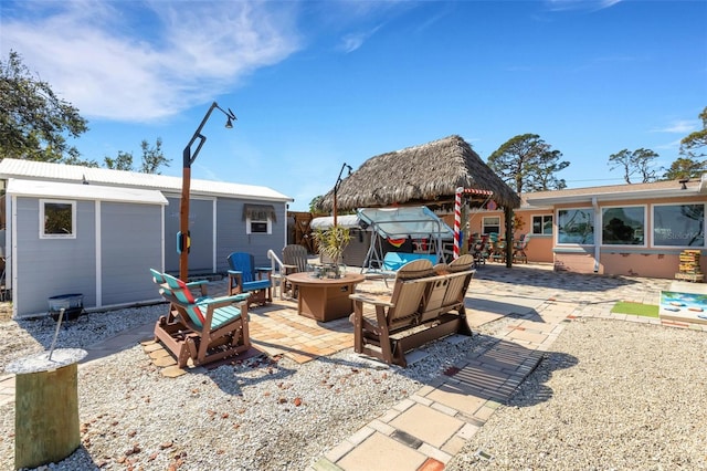 view of patio / terrace with a fire pit and an outdoor structure