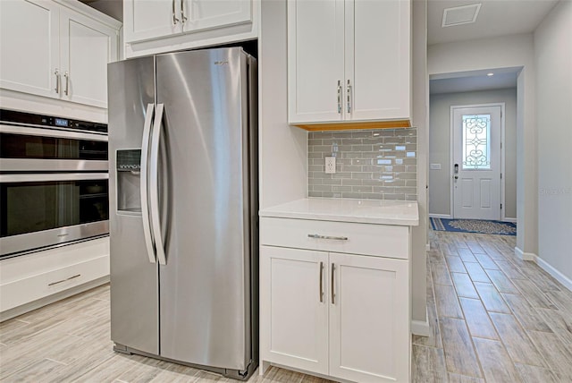 kitchen with white cabinetry, appliances with stainless steel finishes, and decorative backsplash