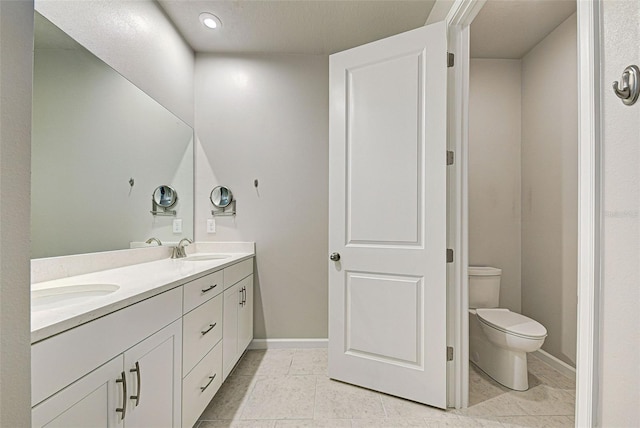 bathroom featuring tile patterned floors, vanity, and toilet