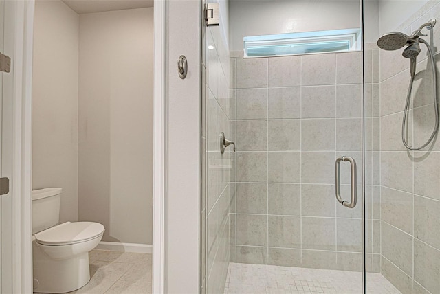 bathroom featuring an enclosed shower, tile patterned flooring, and toilet