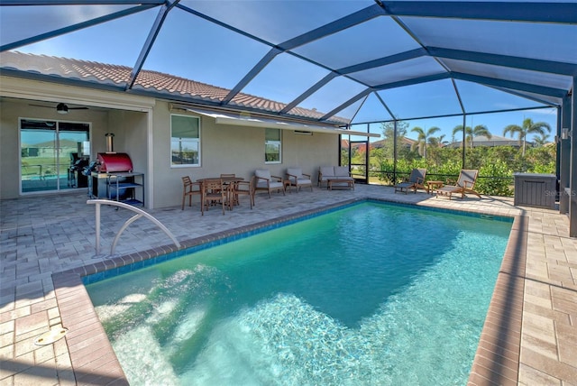 view of swimming pool featuring a patio area, ceiling fan, and glass enclosure