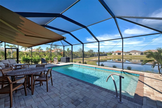 view of pool with a water view, a patio, and glass enclosure