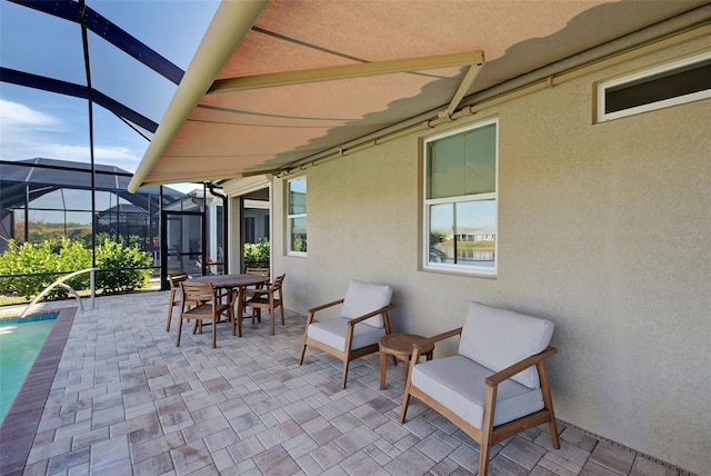 view of patio / terrace featuring a pool and glass enclosure