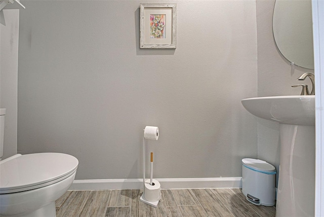 bathroom featuring wood-type flooring, sink, and toilet