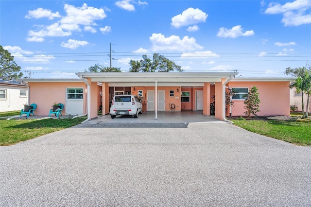 view of front facade with a carport and a front lawn