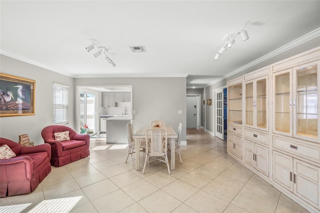 tiled dining area with rail lighting and crown molding