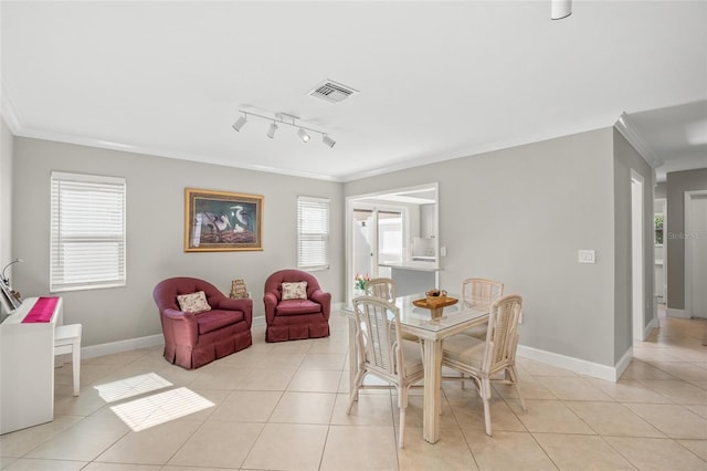 tiled dining space featuring crown molding