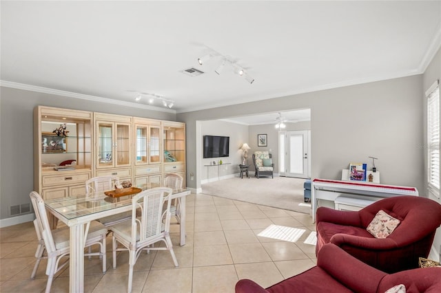 tiled dining space featuring crown molding, ceiling fan, and track lighting