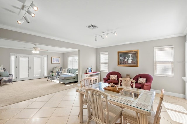 dining space with light colored carpet, ornamental molding, french doors, and ceiling fan