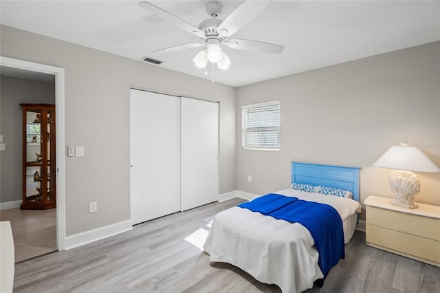 bedroom featuring ceiling fan, a closet, and light wood-type flooring