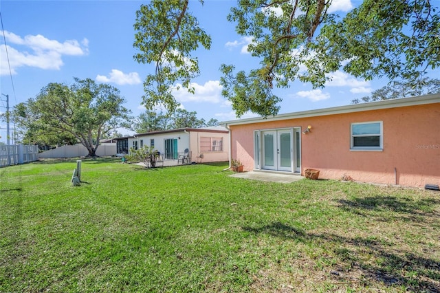 rear view of property featuring a lawn and french doors